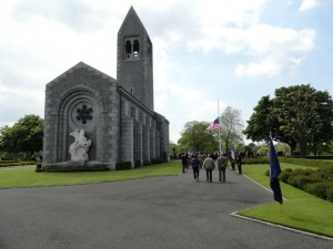 Veterans and relatives pass beneath the Stars and Stripes flown at half-mast ta the St James Cemetery Memorial Day service 26 May 2013